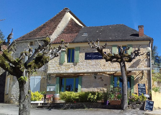 Charme authentique d'une bâtisse lotoise, avec ses volets verts et sa terrasse ombragée, incarnant l'âme du patrimoine local