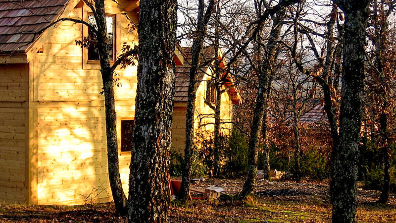 Chalet en bois nichée dans la forêt automnale, illuminée de chaleur et de sérénité pour vos nuits en Lot