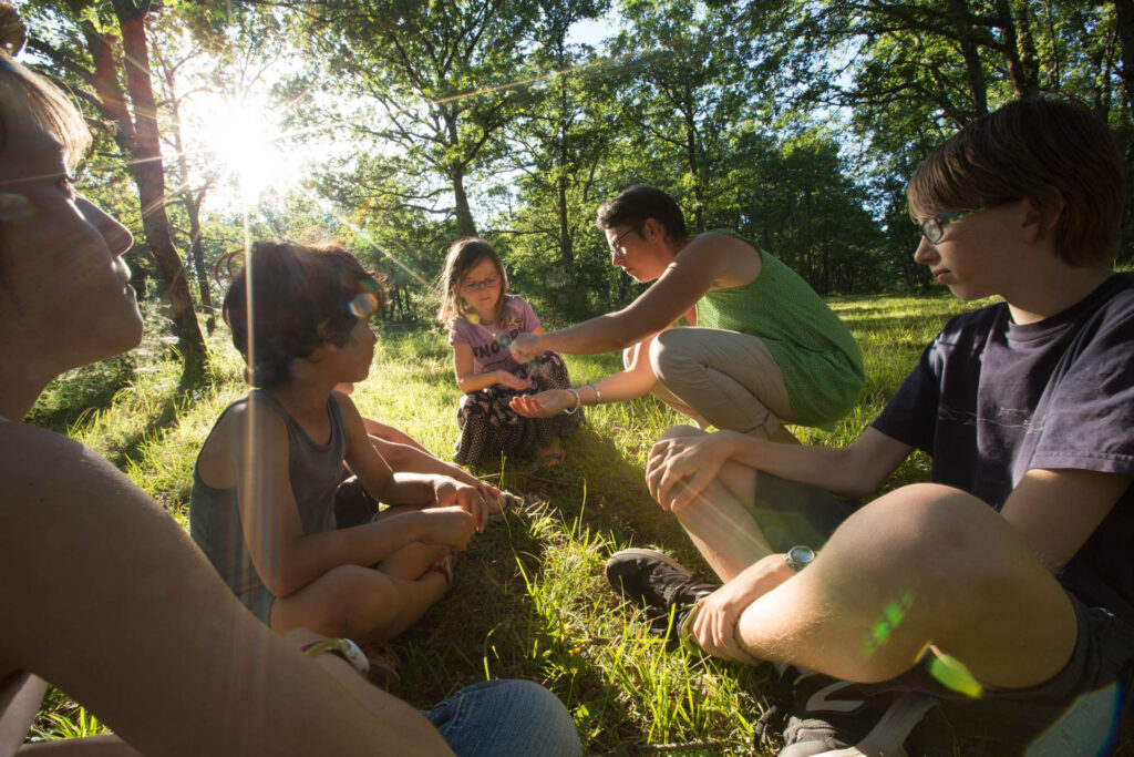 Découverte en famille au cœur de la nature : animateurs passionnés et enfants explorent ensemble les secrets de la forêt du Lot