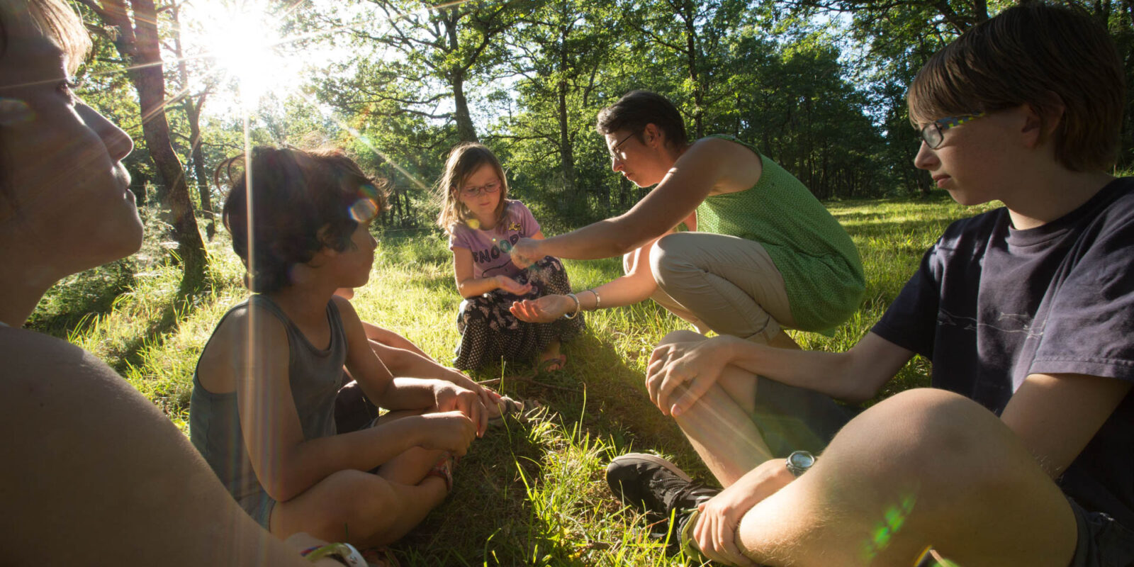 Découverte en famille au cœur de la nature : animateurs passionnés et enfants explorent ensemble les secrets de la forêt du Lot