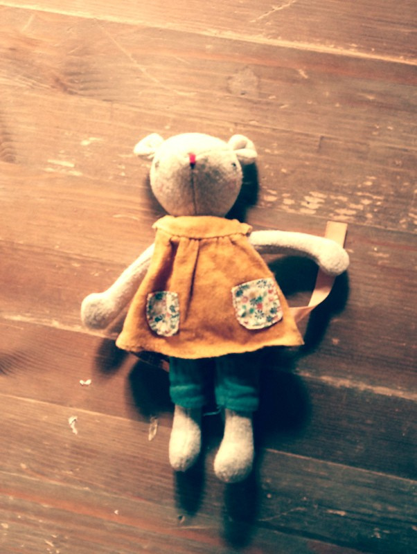 Une petite compagne en peluche attend ses aventures sur le parquet chaleureux de nos chalets