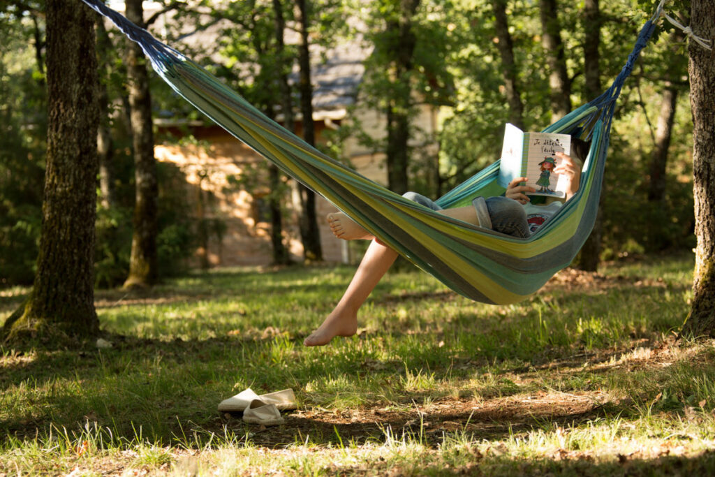 Pause lecture en forêt : détente totale dans un hamac suspendu entre les arbres du Bois de Faral