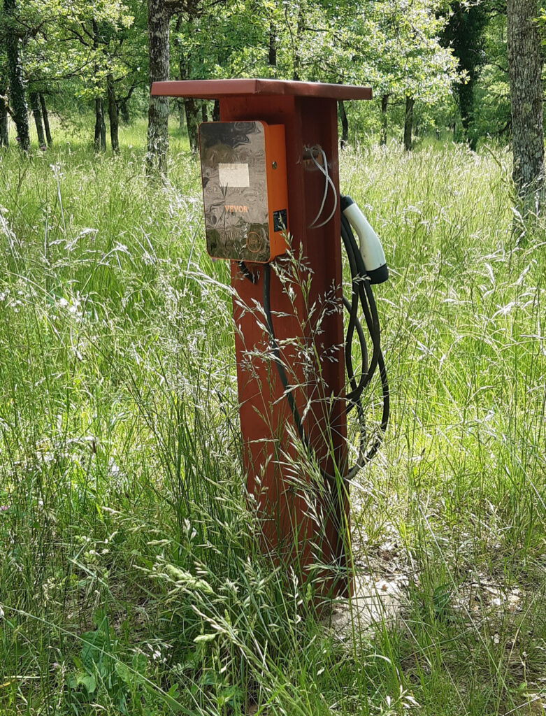 Une ancienne pompe à essence oubliée au cœur des bois, témoin du passé rural du Lot