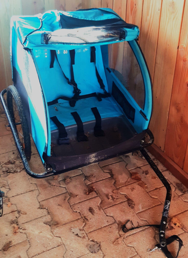 Remorque de vélo turquoise prête pour les aventures en famille à travers les paysages du Lot