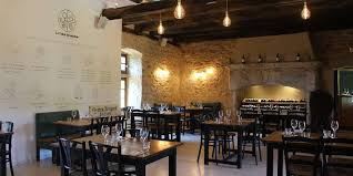 Salle à manger chaleureuse aux pierres apparentes, illuminée par des luminaires suspendus, prête à accueillir vos repas en famille