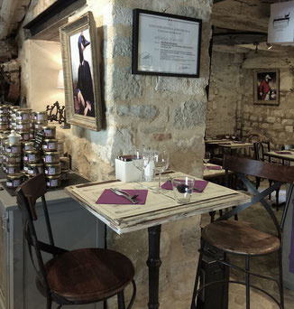 Salon de thé intimiste aux murs de pierre brute, où tradition et authenticité créent une atmosphère chaleureuse et intemporelle