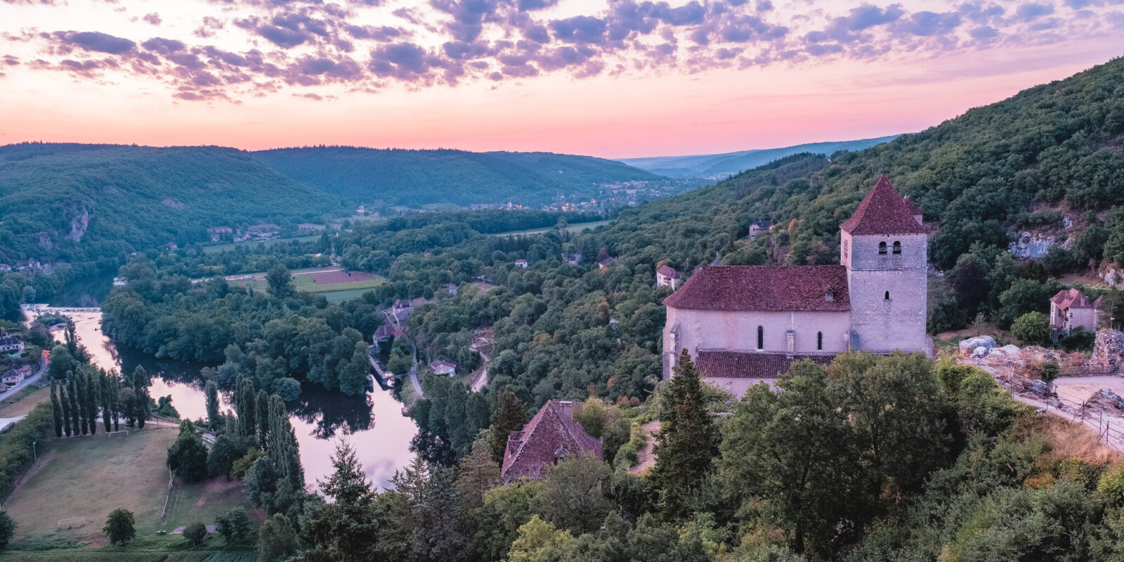 Les vallées verdoyantes du Lot se déploient au coucher de soleil, entre histoire médiévale et nature sauvage préservée